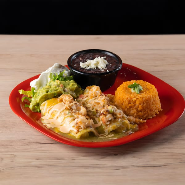 Mexican enchiladas with rice, black beans, guacamole, and sour cream on a red plate.